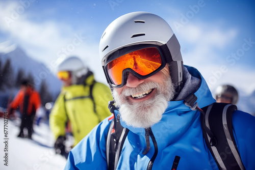 A smiling old man on the ski slopes in a winter sunny day. © Andrea Raffin