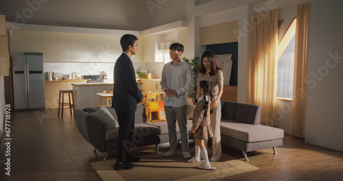 Professional Real Estate Agent Welcomes Young Couple at Home Showing. Korean Young Couple Viewing New Property and Ready to Become Homeowners. Spacious Bright Apartment with Big Windows