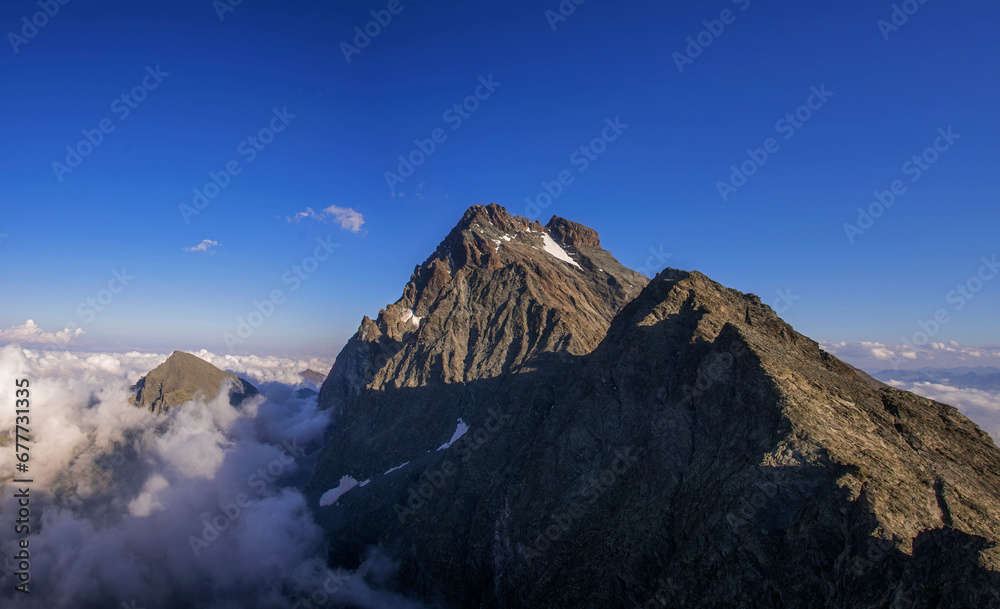 Summer panoramic view of Monviso (Mount Viso or Monte Viso, 3841 metres), the symbol of the Cottian Alps, taken at sunset from an observation point 3100 meters above sea level. Piedmont, Italy.