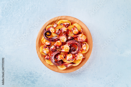 Pulpo a la gallega, Spanish octopus snack, Galician dish, overhead flat lay shot on a slate background photo