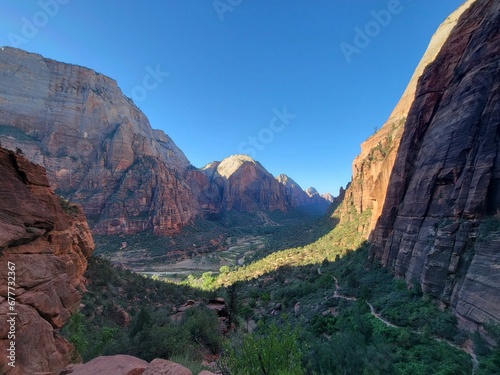 Beautiful view of huge rocks and green trees in a forest under the blue sky