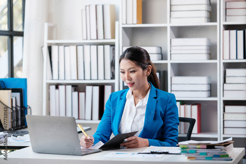 Portrait of an attractive young businesswoman working on her laptop while sitting in the office. Portrait of an attractive young businesswoman working on her laptop while sitting in the office.