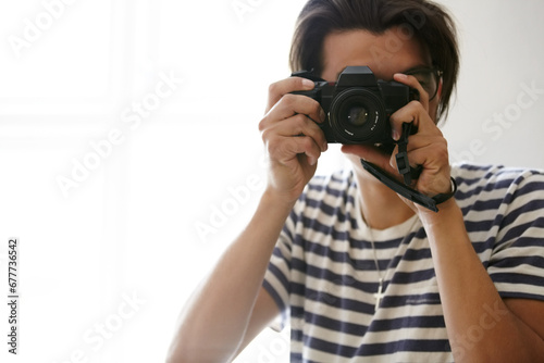 Man, camera and photographer with vision, creative and art in apartment, pictures and inspiration. Male person, confident and photography or lens, vintage technology and retro equipment or gadget