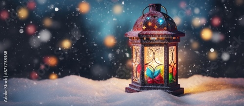  a colorful lantern sitting on top of a pile of snow on top of a pile of snow next to a christmas tree.