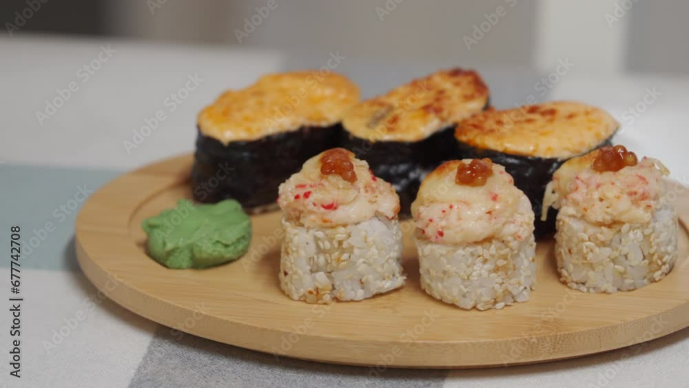 woman eating sushi, set of different rolls sushi on wooden plate, japanese cuisine close-up woman eating sushi, set of different rolls sushi on wooden plate, japanese cuisine close-up