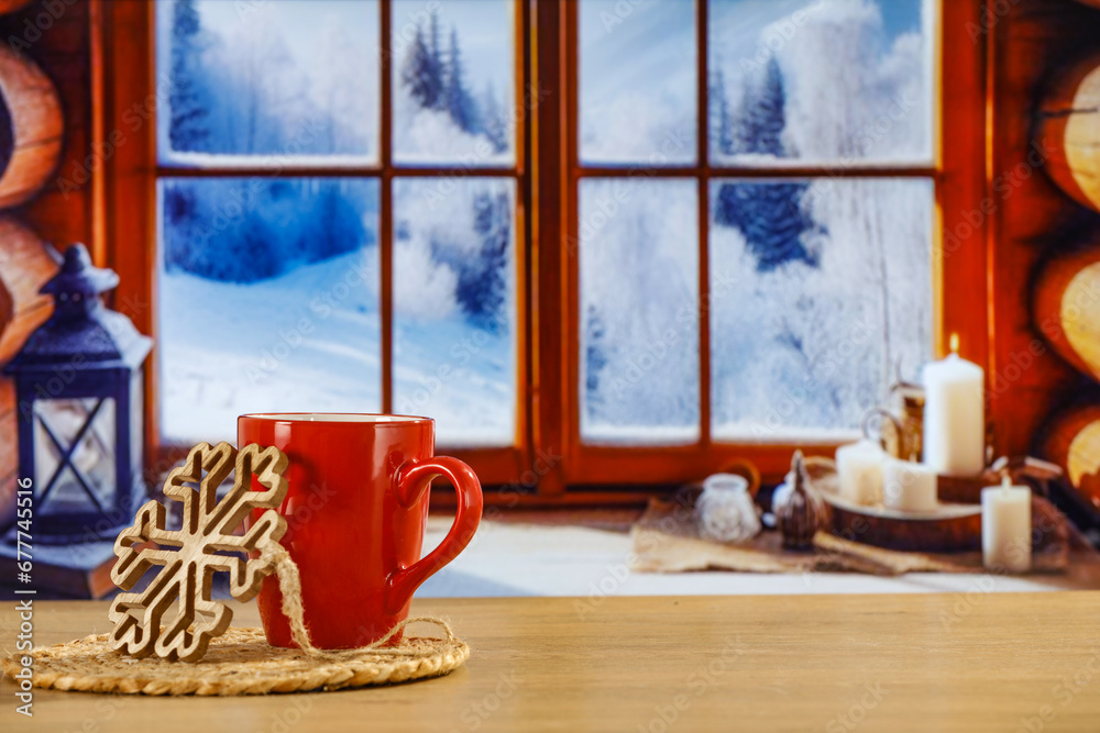 Red mug of hot drink and winter christmas background of window sill. Empty space for your decoration. 