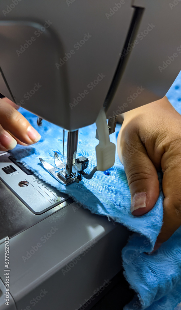 Closeup shot of seamstress hands working on a sewing machine