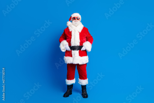 Full body photo of retired old man touch belt defile shopping wear trendy santa claus costume coat isolated on blue color background