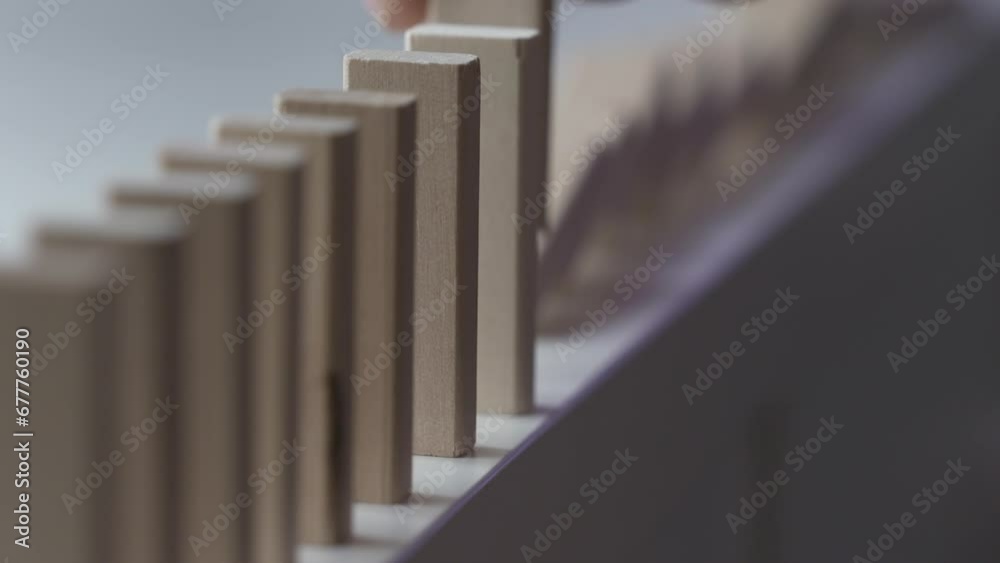 male hand puts wooden domino blocks in a line, domino effect slow motion