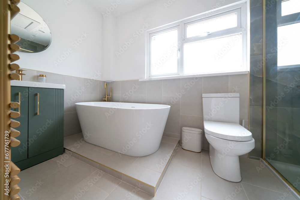 Bright, modern bathroom with white bathroom suite and green cabinet. Bright, modern bathroom with white bathroom suite and green cabinet.