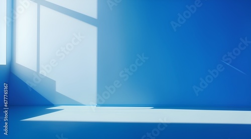 For design or creative work, This is a beautiful blue backdrop image of an empty area in blue tones with play of light and shadow on the wall and floor. Blue background for product presentation