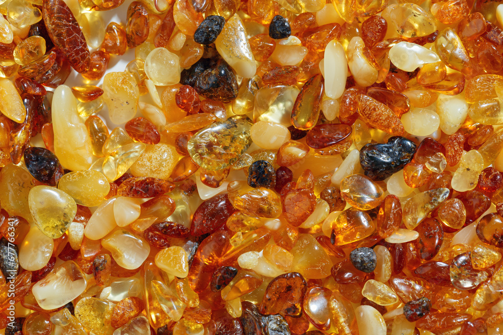 Amber texture background, small stones yellow orange gradient color. Natural gemstone mineral for jewelry. Top view Amber textured fon. Sunstones pieces ancient resin. Transparent pieces gem.
