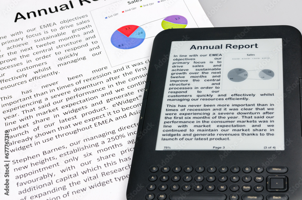 Fototapeta premium E-reader showing a company annual report with a printed copy