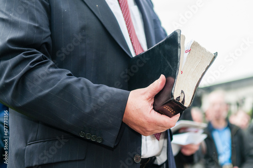 Minister holding a large, well used bible photo