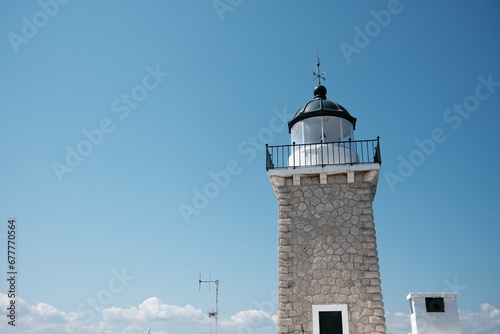 Low angle shot of a lighthouse in Greece in the background of the clear blue sky