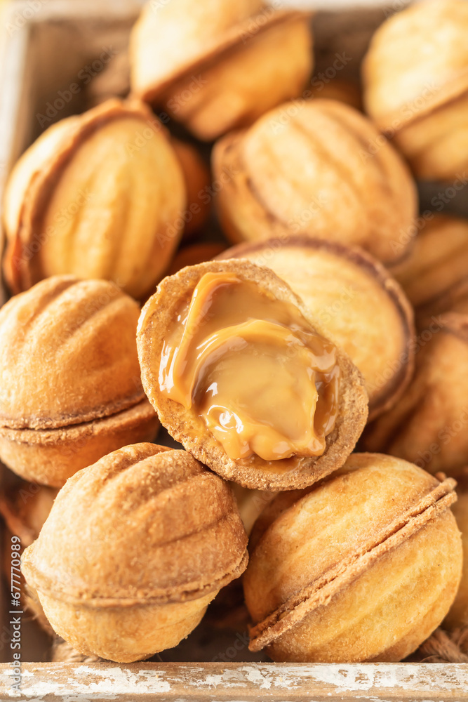 Box of tasty walnut shaped cookies with boiled condensed milk close up. Traditional christmas cookies oreshki