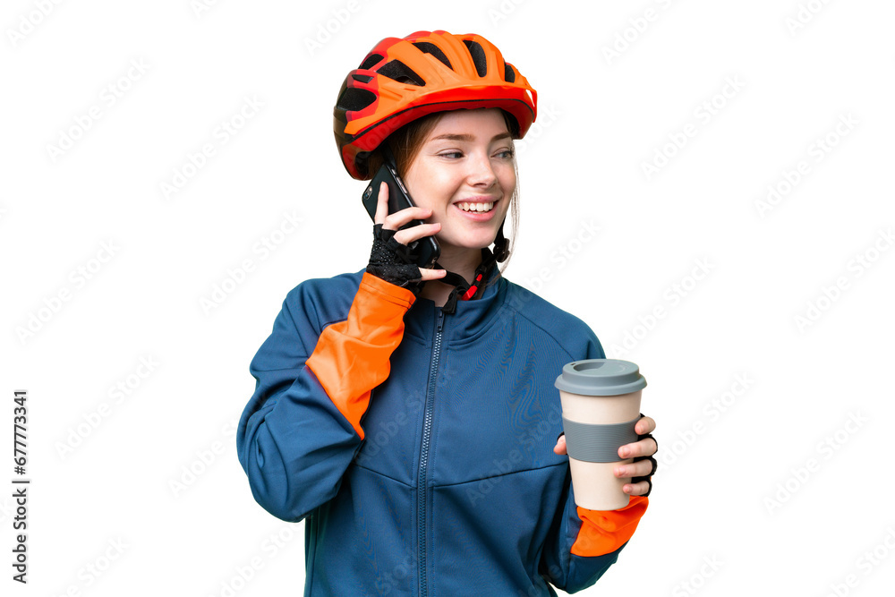 Young cyclist woman over isolated chroma key background holding coffee to take away and a mobile Young cyclist woman over isolated chroma key background holding coffee to take away and a mobile