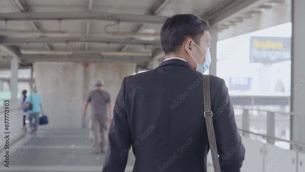 male businessman wearing a mask is traveling to work by public transportation. male businessman wearing a mask is traveling to work by public transportation.