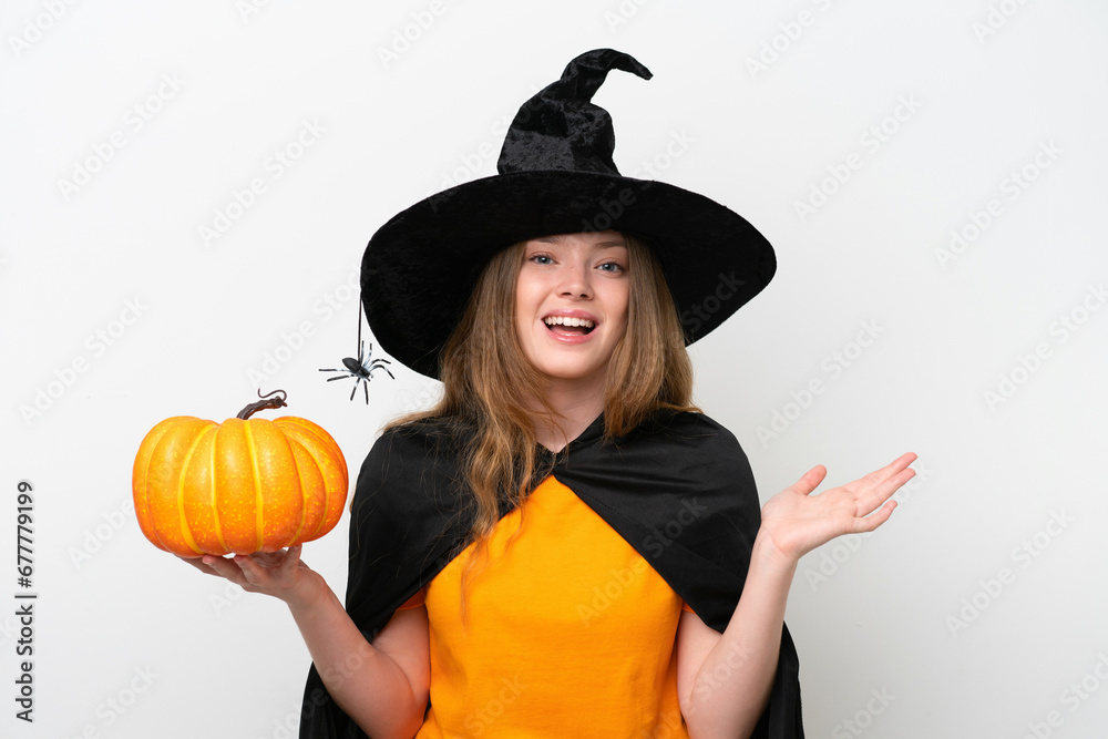 Young pretty woman costume as witch holding a pumpkin isolated on white background with shocked facial expression Young pretty woman costume as witch holding a pumpkin isolated on white background with shocked facial expression
