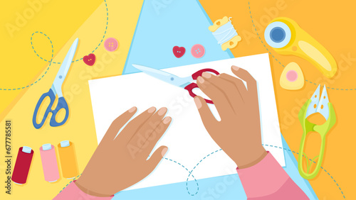 Two dark-skinned female hands on a background of sewing tools