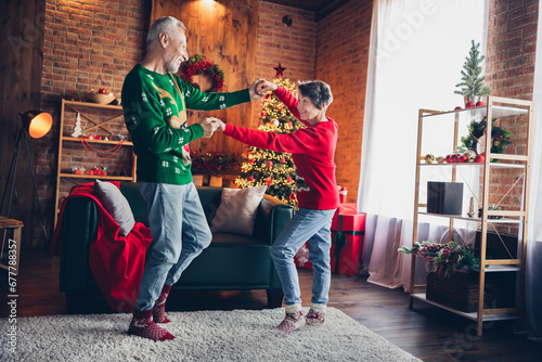 Full body photo of two peaceful positive aged people hold hands dancing newyear magic time indoors