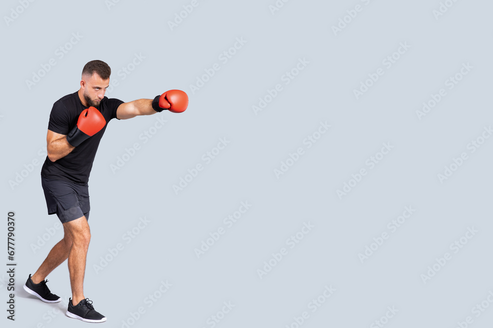 Serious millennial caucasian man in sportswear boxing gloves fight with fist Serious millennial caucasian man in sportswear boxing gloves fight with fist
