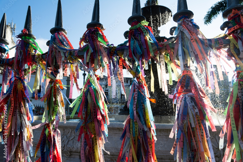 Fototapeta premium View of hundreds of souvenir ribbons tied to an iron railing in Largo Terreiro de Jesus, Pelourinho, historic center of the city of Salvador, Bahia.