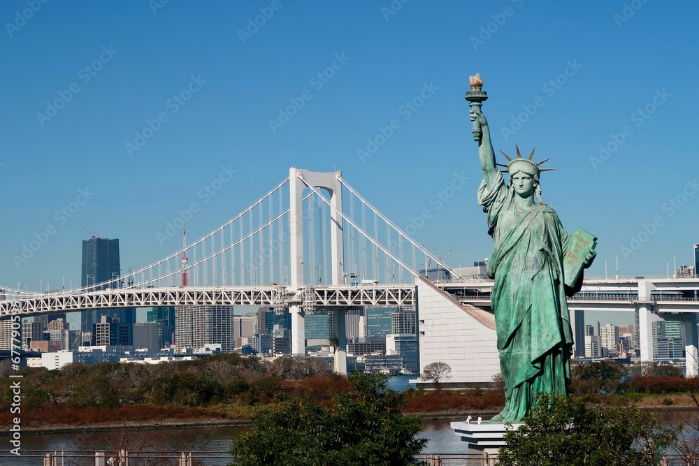 Obraz premium New York The Statue of Liberty with a bridge and tall buildings in the background, USA