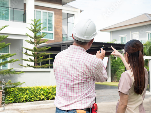 Owner and engineer are inspecting a new house at front yard. Checklist a new house. photo