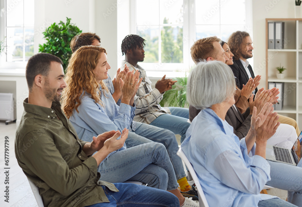 Group of happy joyful business people applaudding to speaker sitting on chairs in a meeting room. Successful coworkers and company employees clapping a colleague on business training or conference. Group of happy joyful business people applaudding to speaker sitting on chairs in a meeting room. Successful coworkers and company employees clapping a colleague on business training or conference.