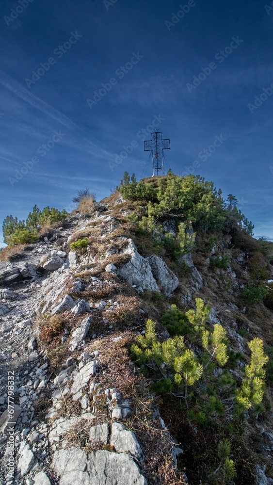 Path leading to a mountain peak with its iconic Metall cross Path leading to a mountain peak with its iconic Metall cross