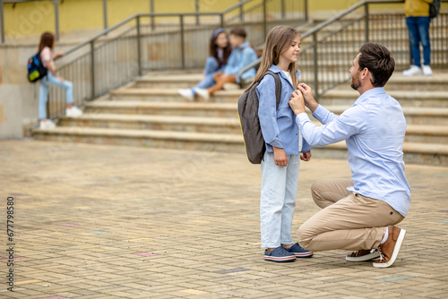 Dark-haired man with his daughter in the school yard