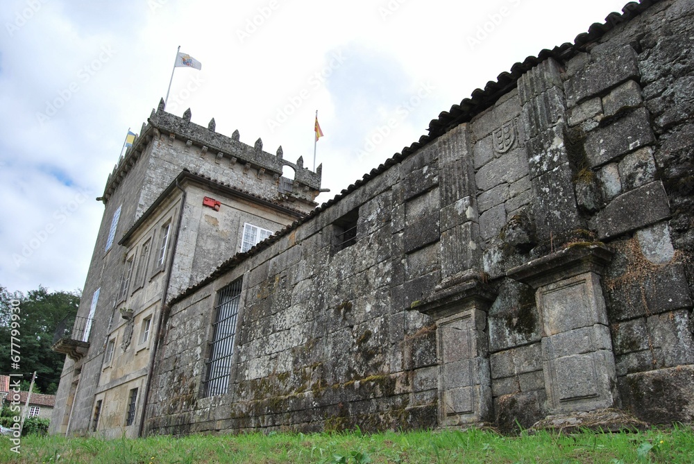 Exterior of an old architecture with flags on the top in the historical landmark Pazo de Oca, Spain