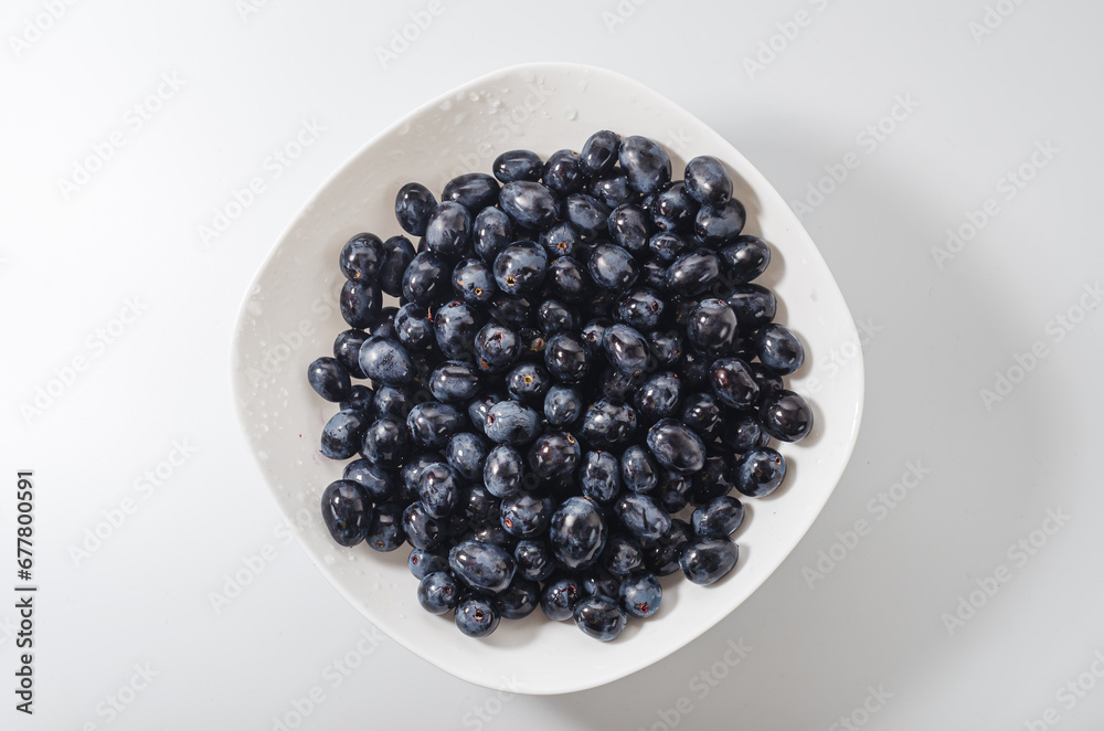 Blue grapes bunches on white plate. Healthy nutrition, health Blue grapes bunches on white plate. Healthy nutrition, health