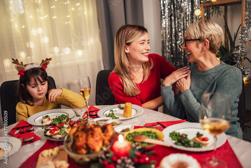 Photo captures the warmth and joy of a Christmas dinner with a beloved grandmother  mother  father  and daughter. 