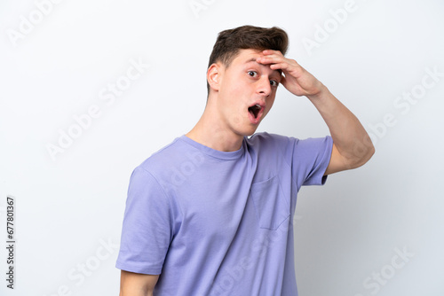 Young handsome Brazilian man isolated on white background doing surprise gesture while looking to the side