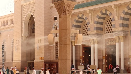 City of Medina in the Kingdom of Saudi Arabia.
‎October ‎28, ‎2023: Fan spray cool water during hot day in Medina on the square near Masjid Al Nabawi or Prophet Muhammed Mosque in Medina photo