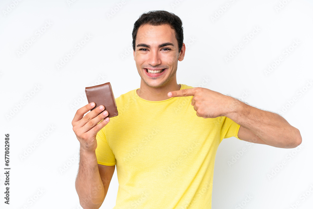 Young caucasian man holding a wallet isolated on white background and pointing it Young caucasian man holding a wallet isolated on white background and pointing it