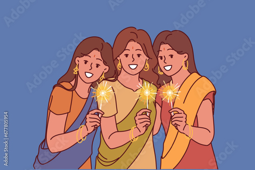 Indian women with sparklers celebrate Diwali festival, dressed in traditional national clothes. Three girls from india participating in Diwali event and wishing to introduce you to indian culture
