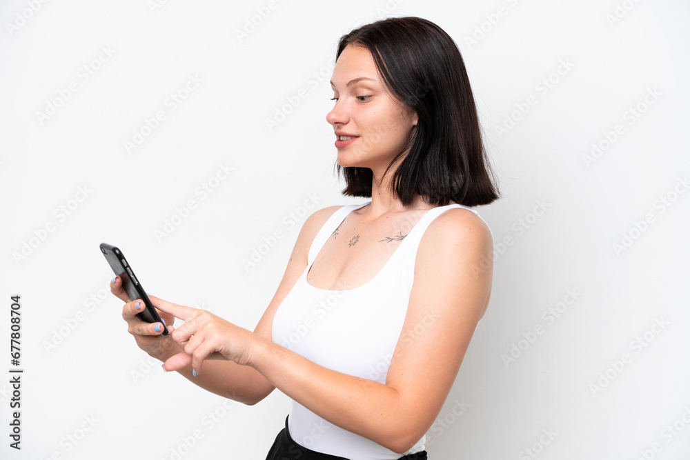 Young caucasian woman isolated on white background sending a message or email with the mobile Young caucasian woman isolated on white background sending a message or email with the mobile