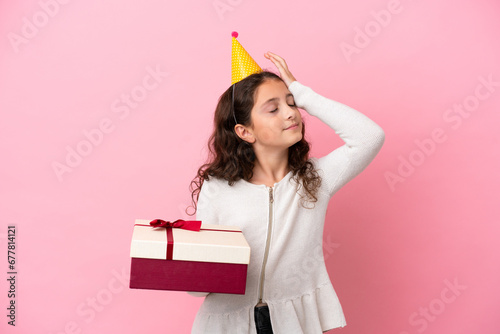 Little caucasian girl holding a gift isolated on pink background has realized something and intending the solution
