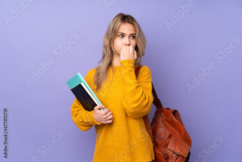 Teenager Russian student girl isolated on purple background nervous and scared putting hands to mouth