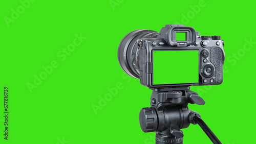 Photo camera with lens. Digital or Dslr camera on tripod. Green screen or Chroma key. Photographer or videographer studio for recording film project. Professional blogger, television equipment