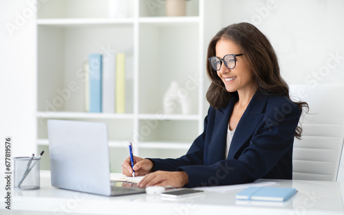 Successful businesswoman working on laptop at office