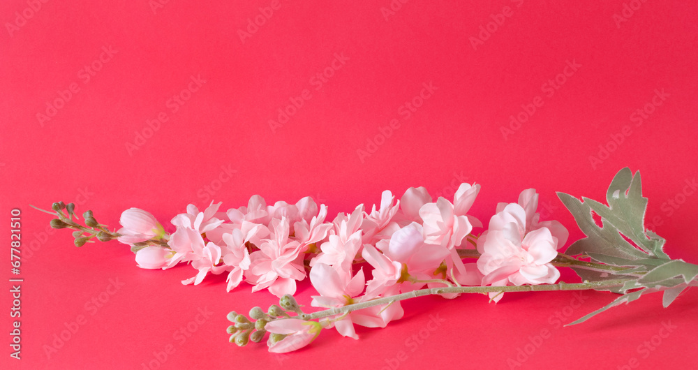 Bouquet of delicate artificial flowers on pink background.