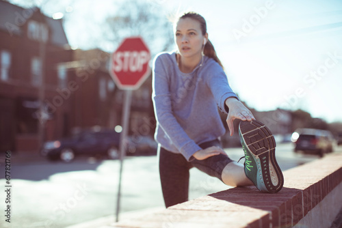 Young woman stretching before running outdoors
