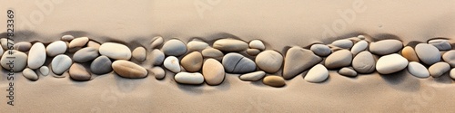 Panoramic view of a line of stones embedded in the sandy shoreline, creating a tranquil and visually captivating scene.