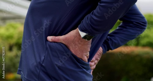 Senior man, back pain and injury with hands, outdoor and tendinitis for arthritis, osteoporosis and park. Health issue, retired or sick with bone, upset and ache for muscle tension, strain and hurt photo