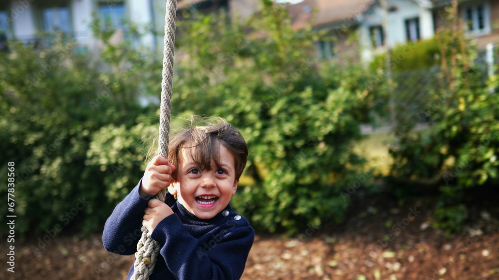 Excited Child Enjoying Rope Slide Amidst Fall Foliage, Joyful Caucasian Child Sliding Down Rope Between Trees in Autumn Excited Child Enjoying Rope Slide Amidst Fall Foliage, Joyful Caucasian Child Sliding Down Rope Between Trees in Autumn