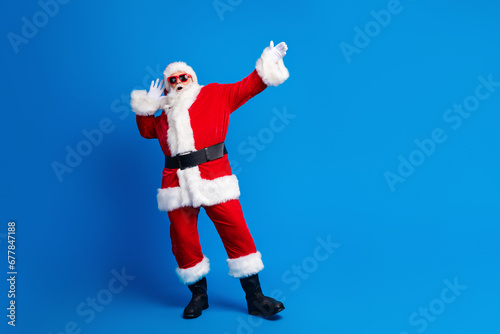 Full body photo of retired old man dancing discotheque dressed stylish santa claus costume coat isolated on blue color background